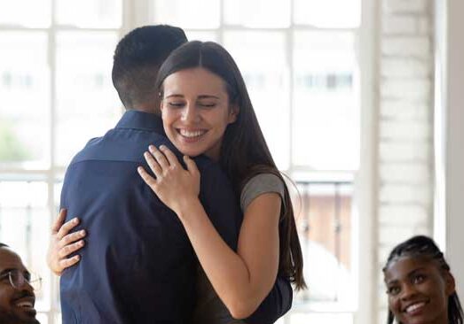 Girl in a recovery meeting hugging her counselor